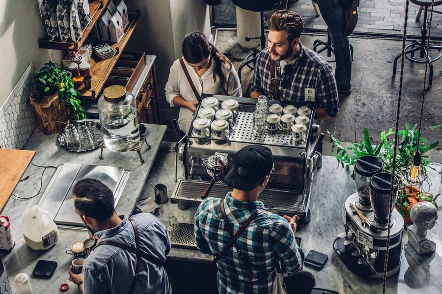 Local small business coffee shop with team working — representing the businesses Optireach helps grow online