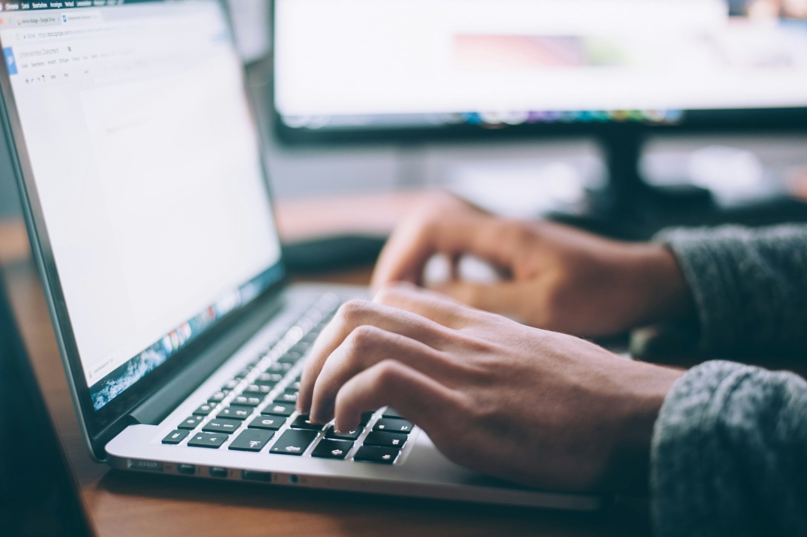 Close-up of hands typing on a laptop keyboard while checking a website's search visibility